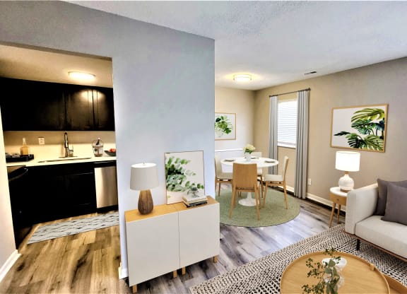 a living room with a couch a table and a chair and a kitchen in the background