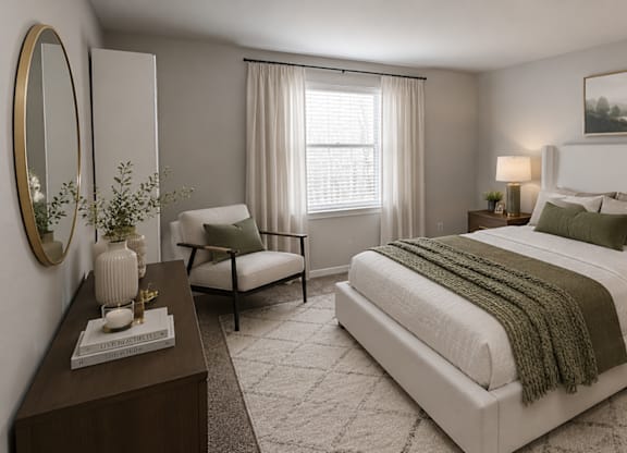 A bedroom with a large bed, a chair, a nightstand, and a plant.