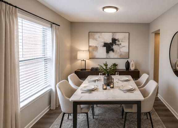 A dining room with a table set for two and a large mirror on the wall.