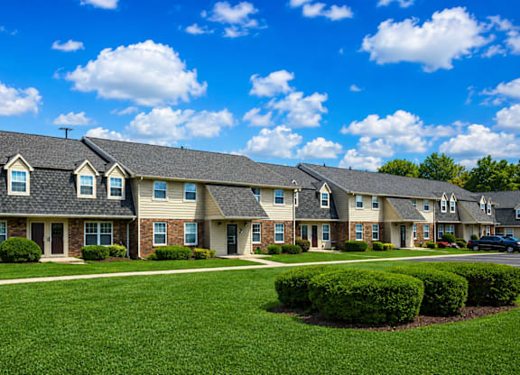 A row of houses with green lawns in front.