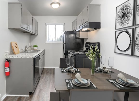 A modern kitchen with a dining table set for two.
