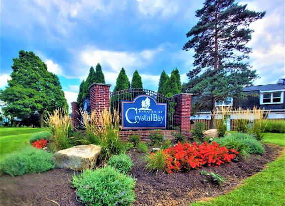 Estates at Crystal Bay sign with a variety of plants and flowers surrounding the sign. 