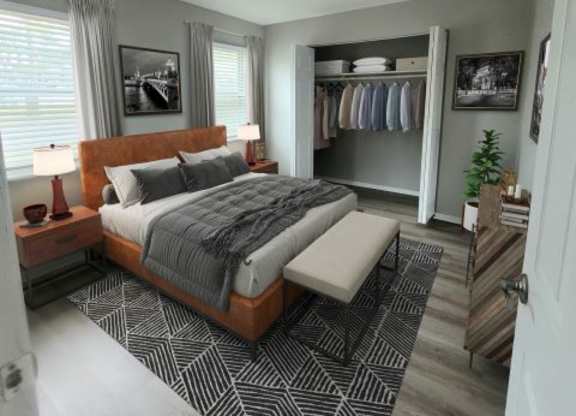 Bedroom with a bed in between two windows and a large closet on the side. 