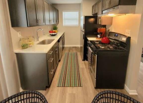 Kitchen with stainless steel appliances and dark wooden cabinets. 