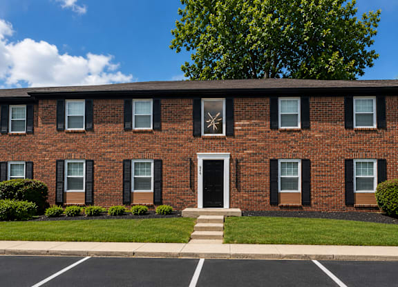 A red brick building with a white door and windows.