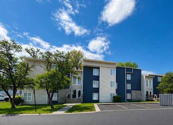 A row of modern apartment buildings with trees in front.