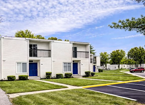 A white apartment building with blue doors and windows.
