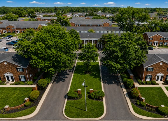 A road with a grassy median leads to a building.