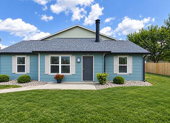 A blue house with a black door and a black chimney.