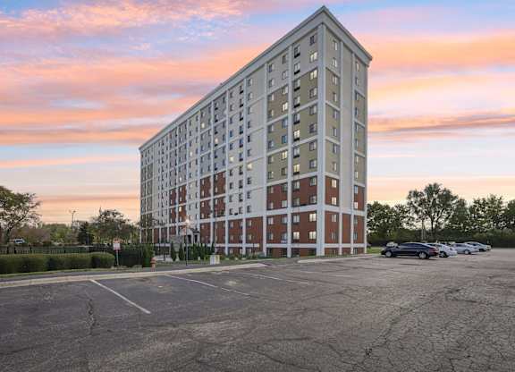 A large, modern building with a parking lot in front of it.