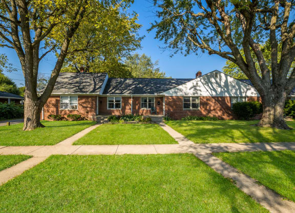 a red brick house with trees in front of it