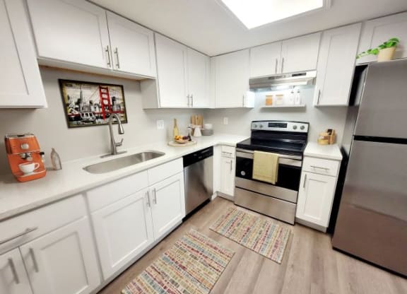 Kitchen with stainless steel appliances and white cabinets. 