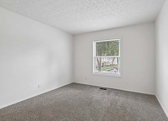 A room with a window and a picture on the wall.