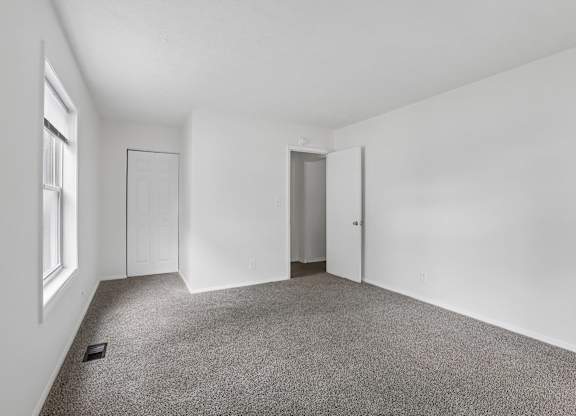 A room with a carpeted floor and white walls.