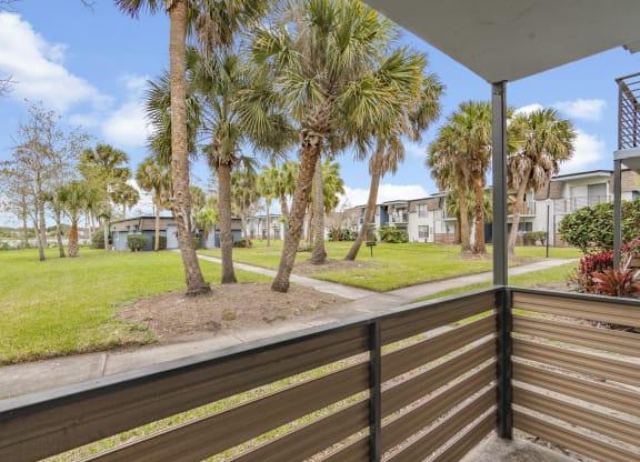 the view from the deck of a house with palm trees