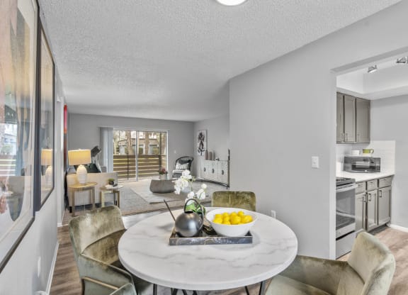 a living room and dining room with a table and chairs and a kitchen