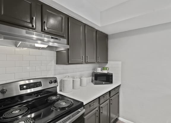 an empty kitchen with a stove and a microwave