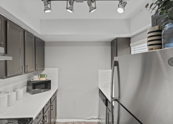 a kitchen with stainless steel appliances and white counter tops
