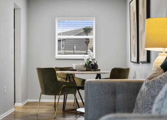 a living room with a table and chairs and a window