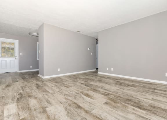 the living room and dining room of an empty house with vinyl flooring