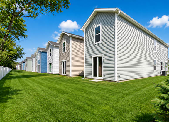 A row of houses with green lawns in front.