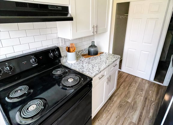 a kitchen with white cabinets and a black stove top oven at Townhomes at 28th, Columbus, IN, 47201