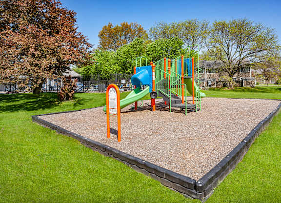 A playground with a slide and a climbing frame.