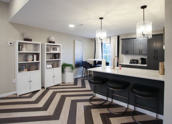 a kitchen and dining room with black cabinets and a striped rug