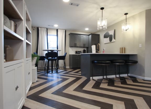 a kitchen and living room with a bar and a striped rug