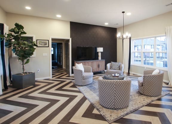 a living room with chairs and a table and a television