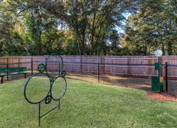 a tennis court in a fenced in area with a bench