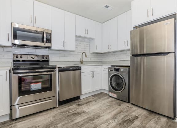 a kitchen with stainless steel appliances and white cabinets