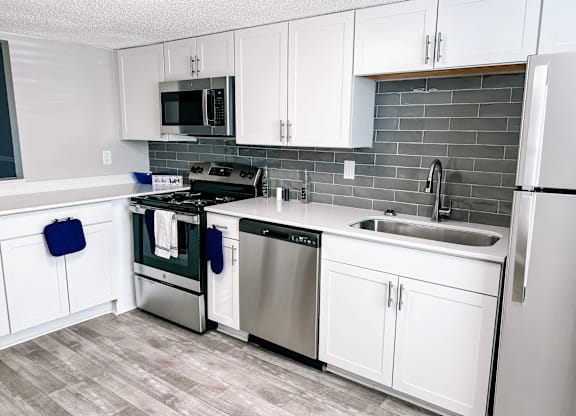 A kitchen with white cabinets and a black stove top.