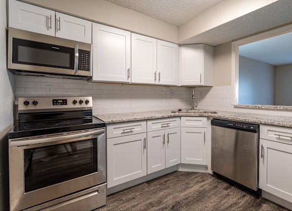 A kitchen with white cabinets and stainless steel appliances.