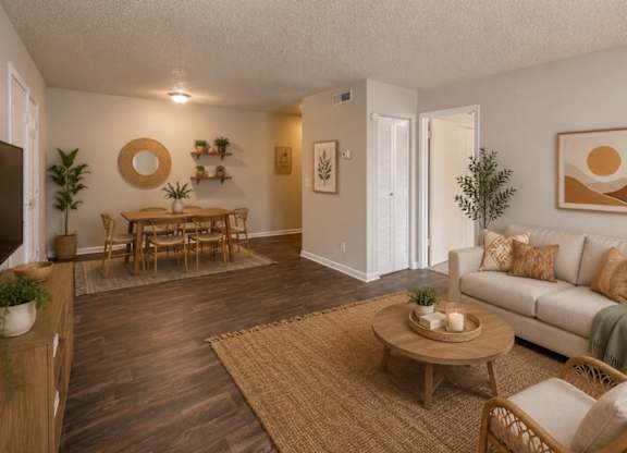 A living room with a white couch, wooden coffee table, and a rug.