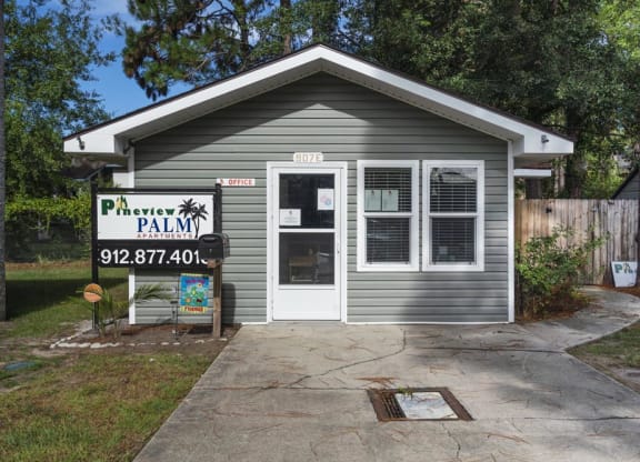 a small gray building with a sign that says pavement palm