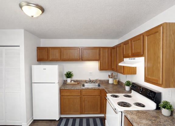 A kitchen with wooden cabinets and a white fridge.