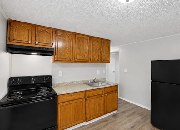 A kitchen with black appliances and wooden cabinets.