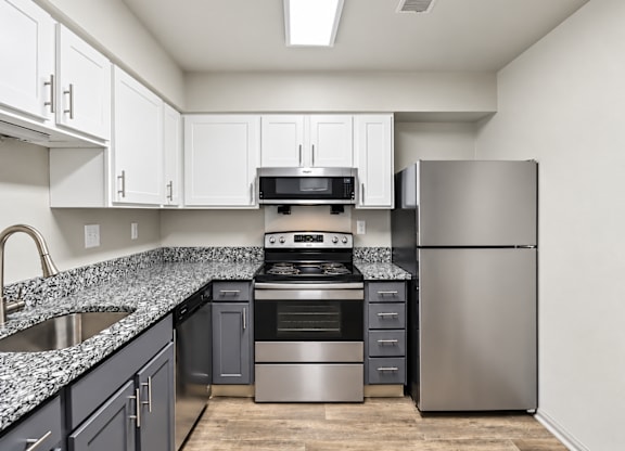 A kitchen with a stove top oven, microwave, and refrigerator.