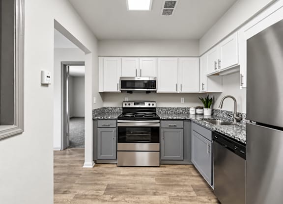 A modern kitchen with stainless steel appliances and white cabinets.