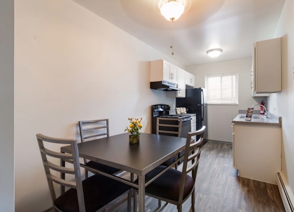 A kitchen with a table and chairs.