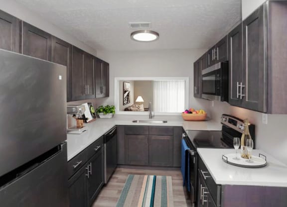 Kitchen with stainless steel appliances and dark wooden cabinets. 