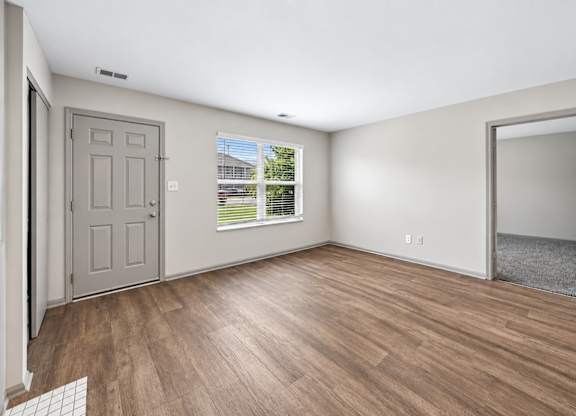 A room with a grey door and a window with blinds.