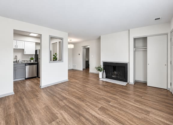 A spacious living room with a fireplace and hardwood floors.