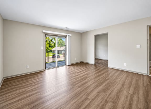 A room with wooden flooring and a sliding glass door.