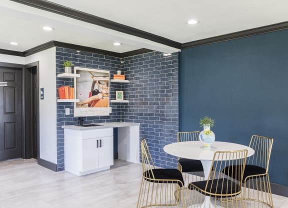 a dining room with blue walls and a white table and chairs