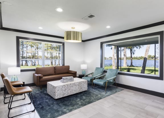 a living room with a couch and chairs and a large window
