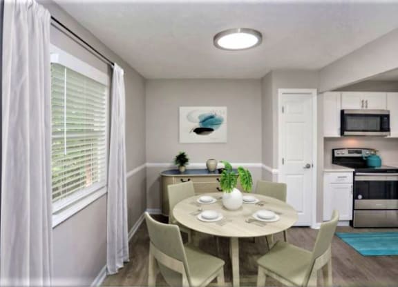 Dining area with a circular table and 4 chairs in between the kitchen and a window.