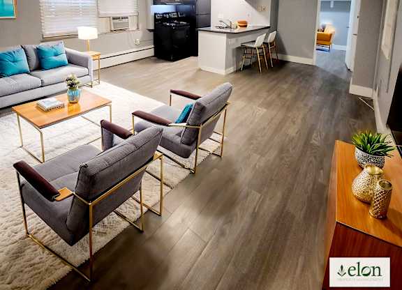 A living room with a grey couch, a coffee table, and a wooden floor.