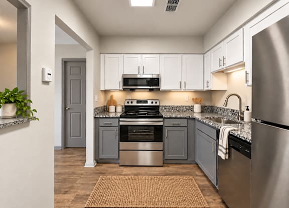 A modern kitchen with stainless steel appliances and a grey door.